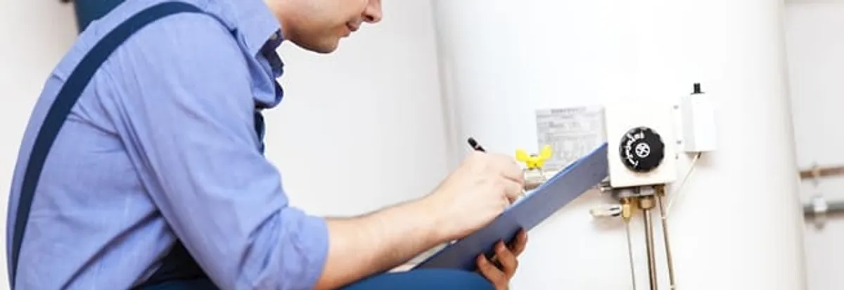 Water heater repair technician inspecting the unit and recording service notes in Tampa, FL